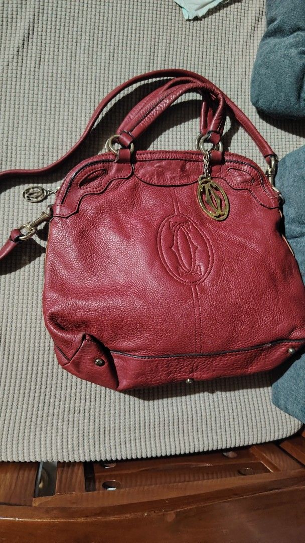 Cartier Red Leather Sling Handbag (Category: Luxury Bags & Wallets) located in Santa Rosa. Submitted by RRRR0520 (Listing ID 1435822893, Image 1). Description: - Red leather handbag - Top handle and detachable shoulder strap - Gold-tone charm and hardware - Textured leather exterior with Cartier logo W U C S WHAT U GET SIGN OF USED PAKI SELF AUTHENTICATE NALANG PO - Metal feet on the bottom.