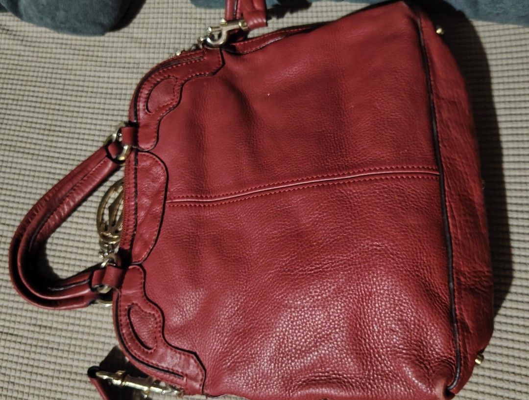 Cartier Red Leather Sling Handbag (Category: Luxury Bags & Wallets) located in Santa Rosa. Submitted by RRRR0520 (Listing ID 1435822893, Image 2). Description: - Red leather handbag - Top handle and detachable shoulder strap - Gold-tone charm and hardware - Textured leather exterior with Cartier logo W U C S WHAT U GET SIGN OF USED PAKI SELF AUTHENTICATE NALANG PO - Metal feet on the bottom.