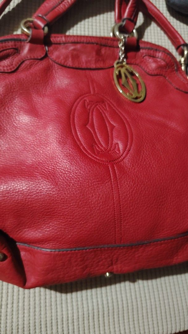 Cartier Red Leather Sling Handbag (Category: Luxury Bags & Wallets) located in Santa Rosa. Submitted by RRRR0520 (Listing ID 1435822893, Image 3). Description: - Red leather handbag - Top handle and detachable shoulder strap - Gold-tone charm and hardware - Textured leather exterior with Cartier logo W U C S WHAT U GET SIGN OF USED PAKI SELF AUTHENTICATE NALANG PO - Metal feet on the bottom.