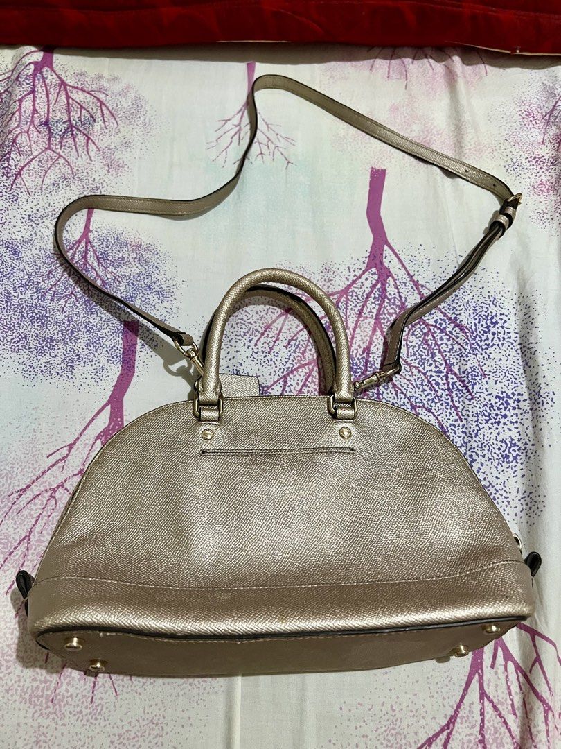 Coach Mini Sierra Satchel Handbag (Category: Luxury Bags & Wallets) located in Dagupan City. Submitted by casadebayongph (Listing ID 1435833636, Image 3). Description: Coach Mini Sierra Satchel handbag features a metallic gold finish. It has a top handle and a detachable shoulder strap. The bag has a zip closure and a Coach hangtag. The bag has a structured shape with a rounded base. With signs of usage sa handle and rubber linings. Ung creed niy