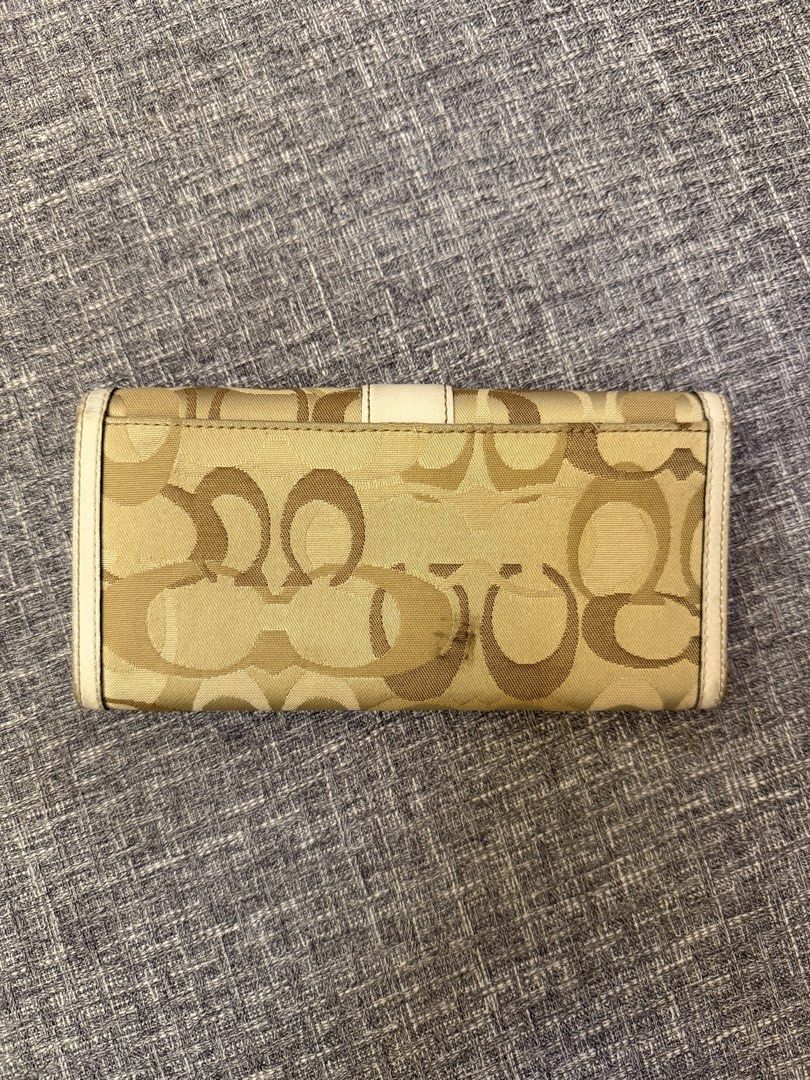 Coach Wallet (Category: Luxury Bags & Wallets) located in San Jose. Submitted by affordabletrendsby_cai (Listing ID 1435715613, Image 2). Description: - Coach wallet with signature print - Beige and white color scheme - Interior: Multiple card slots and zippered compartment - Closure: Snap - Condition: Exterior shows wear and tear.