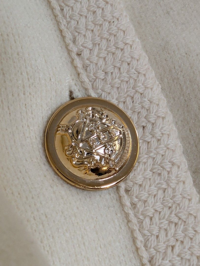 Cream Cardigan with Gold Buttons (Category: Coats, Jackets and Outerwear) located in Tarlac. Submitted by sunshine_shopph (Listing ID 1435779494, Image 2). Description: - Cream-colored cardigan - Long sleeves - Round neckline - Two front pockets - Decorative gold buttons with detailed design - Knitted trim - Lightweight material.
