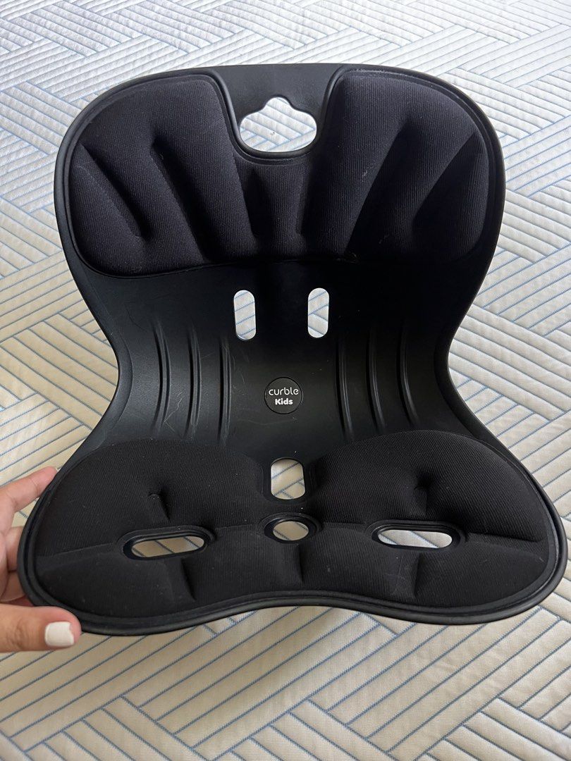 Curble Kids Posture Seat (Category: Chairs) located in Quezon City. Submitted by daday39 (Listing ID 1435738234, Image 1). Description: - Curble Kids posture seat (black). - Designed for kids' posture correction. - Contoured design for comfort. - Padded seating areas. - Features a central opening. - Sturdy frame. - Suitable for various chairs. - Brand name visible..