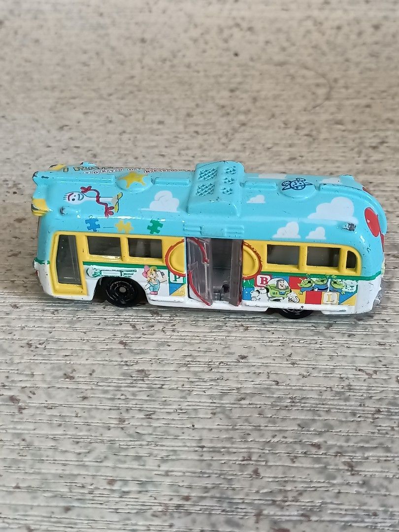 Disney Pixar Toy Story Bus (Category: Vehicle & Diecast Models) located in Quezon City. Submitted by Bernz (Listing ID 1435765639, Image 2). Description: - Toy Story themed bus toy - Light blue body with Toy Story character designs - Mickey Mouse design on the back - Opening door - White and yellow interior.