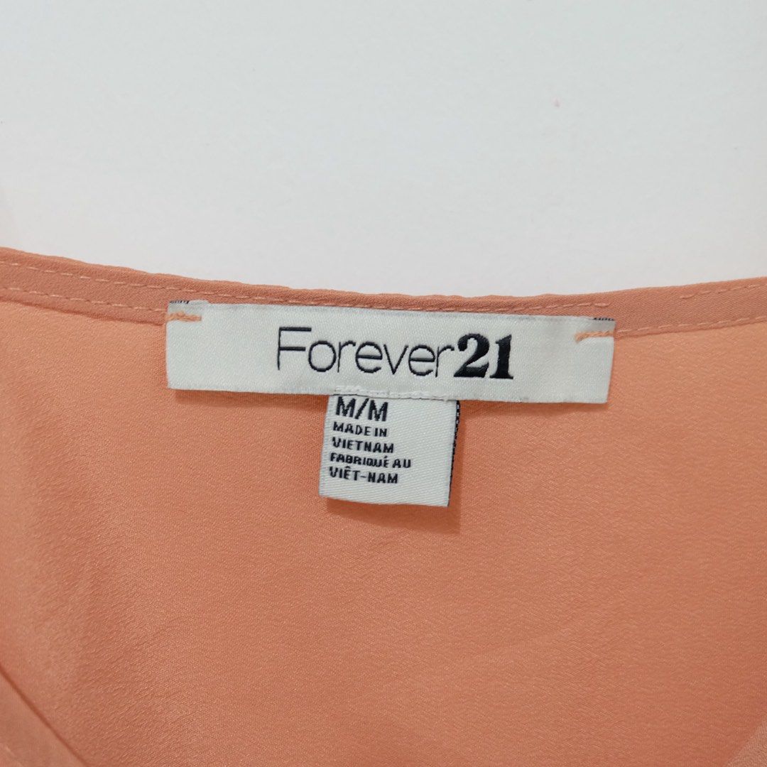 Forever 21 Peach Eyelet Hem Button-Up Camisole (Size M) (Category: Sleeveless) located in Manila. Submitted by thecooldeclutterer (Listing ID 1435860084, Image 3). Description: • Brand: Forever 21 • Size: Medium (M/M) • Color: Peach / Coral • Features: Sleeveless camisole with a V-neckline, functional gold-tone front buttons, and a decorative laser-cut eyelet floral hem • Design: Double spaghetti straps and a straight-cut back KEYWORDS Forever 21