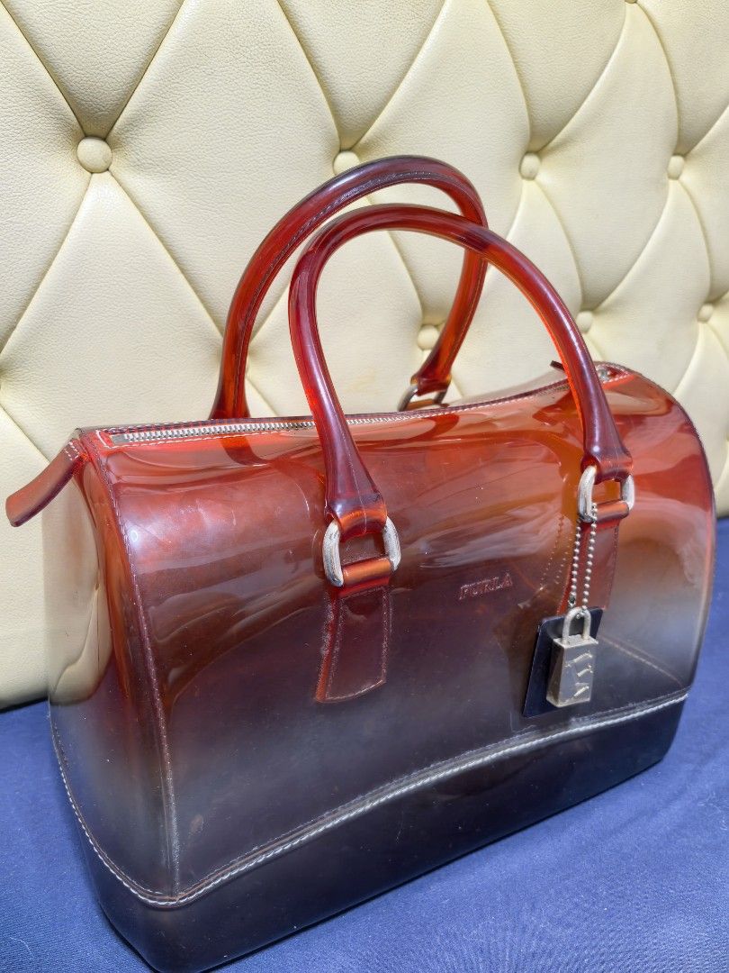 Furla Candy Bag (Category: Luxury Bags & Wallets) located in Makati City. Submitted by reiven2017 (Listing ID 1435817422, Image 2). Description: - Authentic Furla Candy Bag - Gradient design - Red handles - Zipper closure - Detachable tag - Silver-tone lock charm - Transparent body with dark base - Medium size.