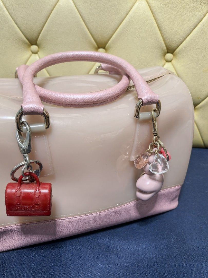 Furla Jelly Bag with Charms (Category: Luxury Bags & Wallets) located in Makati City. Submitted by reiven2017 (Listing ID 1435819456, Image 1). Description: - Authentic Furla jelly bag - Light pink body with pink handles and base - Gold zipper closure - Furla logo lock - Includes red miniature bag charm and pink/clear charms - Silver hardware - Rounded shape.