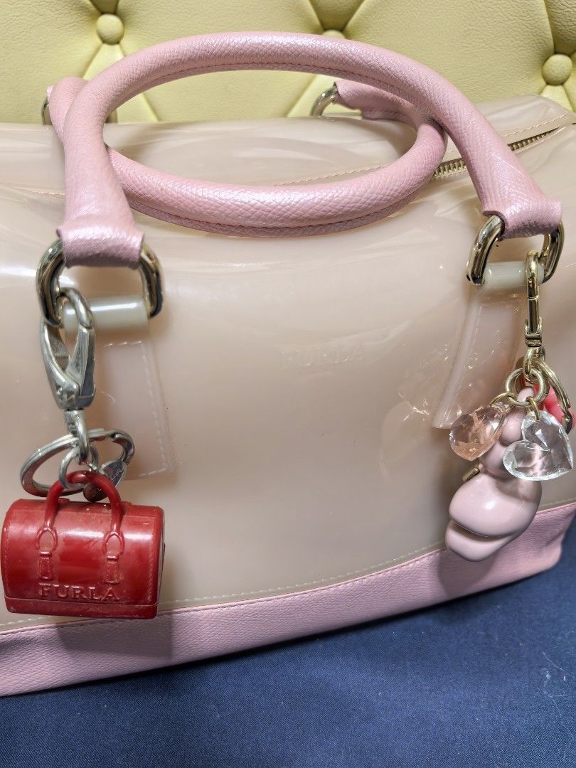 Furla Jelly Bag with Charms (Category: Luxury Bags & Wallets) located in Makati City. Submitted by reiven2017 (Listing ID 1435819456, Image 2). Description: - Authentic Furla jelly bag - Light pink body with pink handles and base - Gold zipper closure - Furla logo lock - Includes red miniature bag charm and pink/clear charms - Silver hardware - Rounded shape.