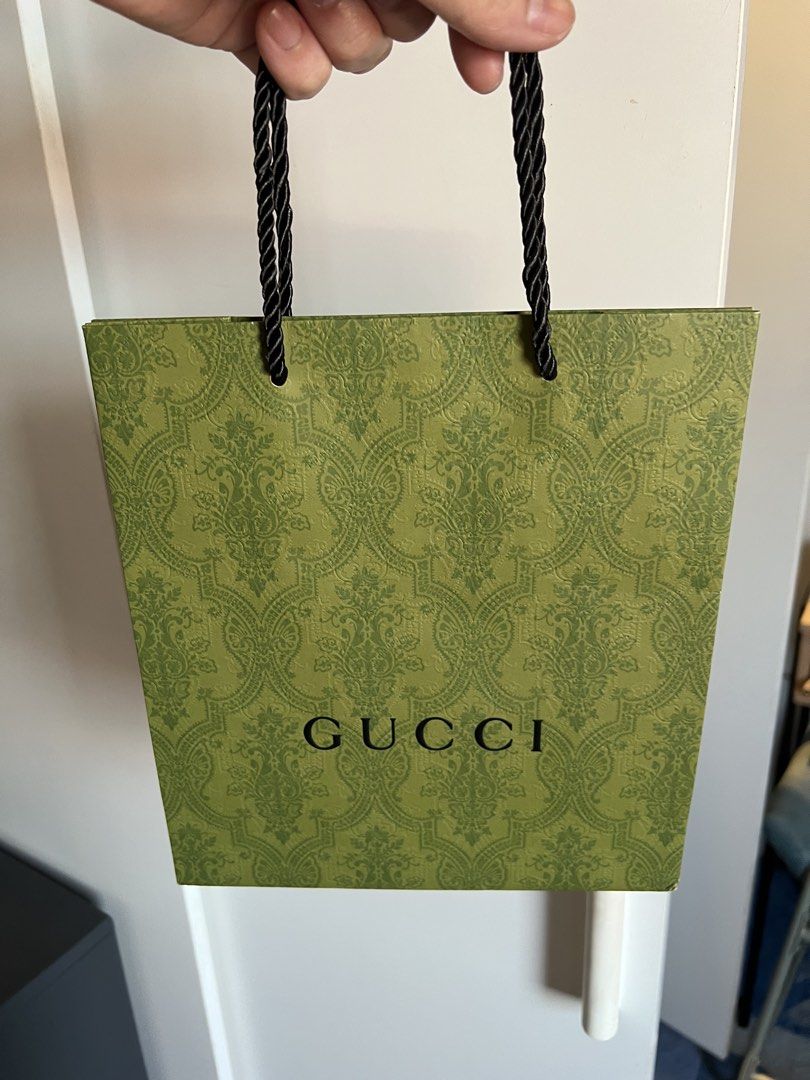 Gucci Paper Bag (Category: Luxury Bags & Wallets) located in Makati City. Submitted by marckyboy (Listing ID 1435813020, Image 1). Description: - Authentic Gucci paper bag - Features green damask pattern - Gucci logo on front - Black rope handles - Ideal for gifting or collecting - Stylish accessory.