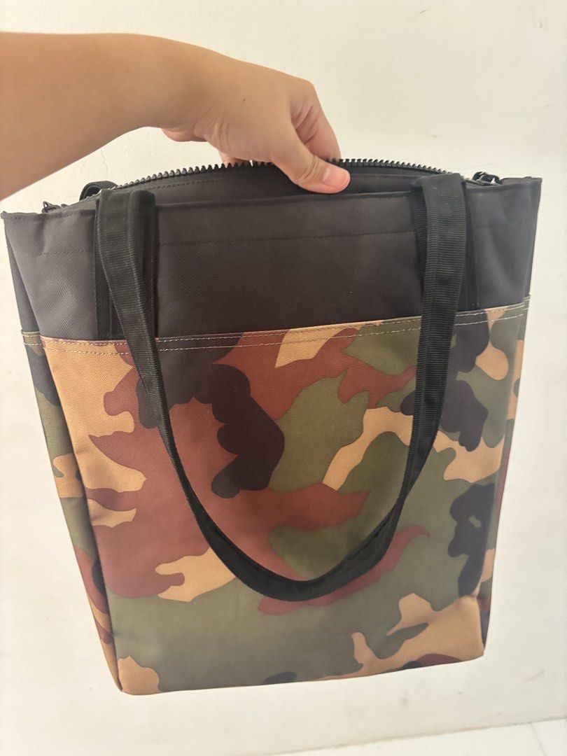Herschel Supply Co. Camo Tote Bag (Category: Tote Bags) located in Bulacan. Submitted by mreyes21 (Listing ID 1435775697, Image 3). Description: - Herschel Supply Co. tote bag - Camouflage pattern - Black top and handles - Zippered main compartment - Small Herschel label - Includes matching bottle holder.