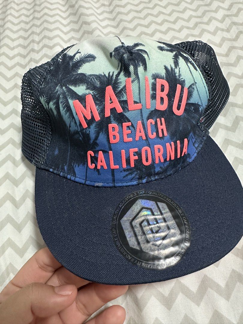 H&M Malibu Beach California Cap (Category: Babies & Kids Fashion) located in Manila. Submitted by classywardrobemanila (Listing ID 1435835818, Image 1). Description: - H&M cap with Malibu Beach California design. - Features a navy blue brim and mesh back. - Adjustable fit. - Size: 92/104 (1 1/2-4Y). - Condition: Good..