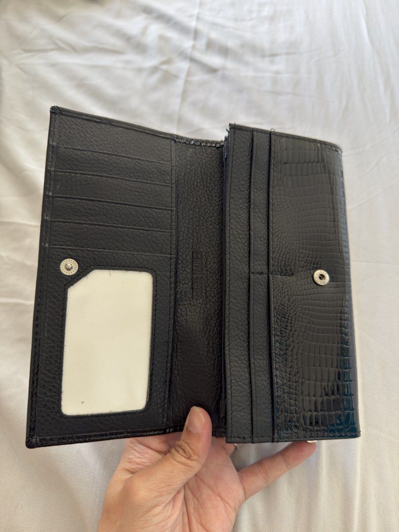 Hongliang Black Crocodile Wallet (Category: Luxury Bags & Wallets) located in Makati City. Submitted by thisisshy (Listing ID 1435782300, Image 2). Description: - Black wallet with crocodile skin pattern - Brand: Hongliang - Multiple compartments for cards and cash - Includes a clear ID window - Zippered pocket for secure storage - Features both snap and clasp closures.