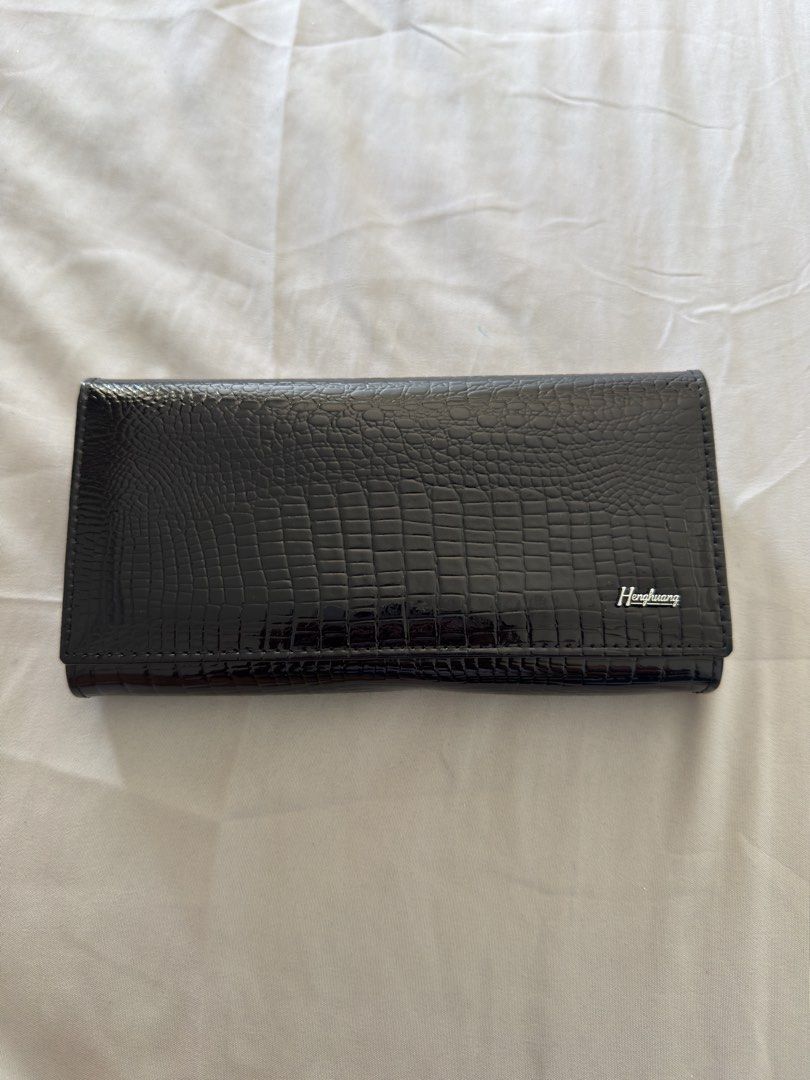 Hongliang Black Crocodile Wallet (Category: Luxury Bags & Wallets) located in Makati City. Submitted by thisisshy (Listing ID 1435782300, Image 1). Description: - Black wallet with crocodile skin pattern - Brand: Hongliang - Multiple compartments for cards and cash - Includes a clear ID window - Zippered pocket for secure storage - Features both snap and clasp closures.
