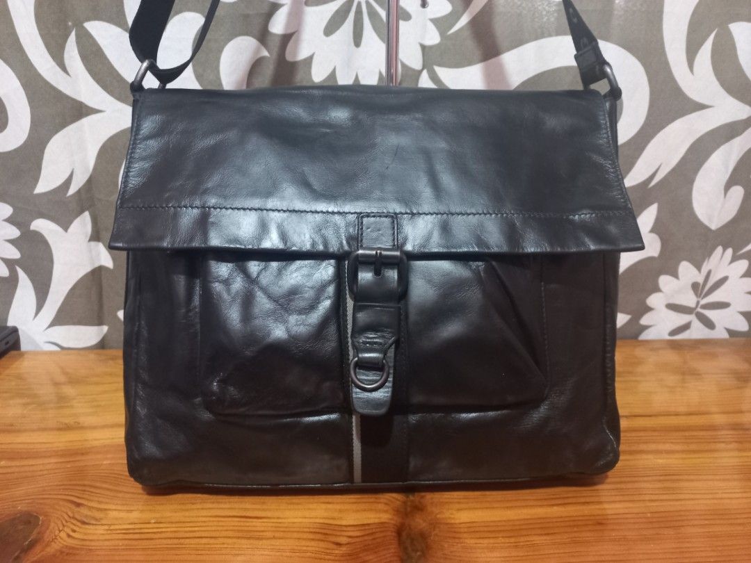 Hugo Boss Black Leather Messenger Bag (Category: Luxury Bags & Wallets) located in Baguio. Submitted by highticket75 (Listing ID 1435735776, Image 2). Description: - Hugo Boss Black leather messenger - Flap with buckle closure - Adjustable shoulder strap - Front zip pocket -H 11', W 13.5", Base 3.25" - Multiple inside pockets - Vertical stripe detail.