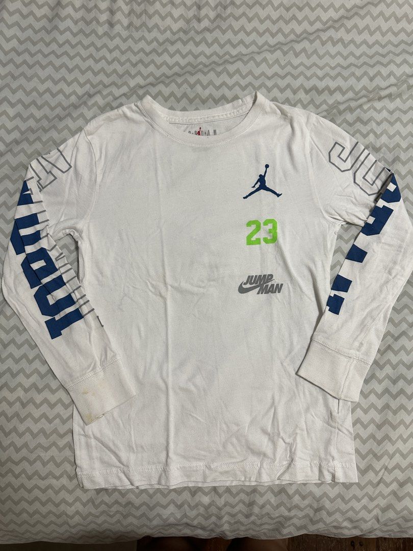 Jordan Long Sleeve Shirt (Category: Babies & Kids Fashion) located in Manila. Submitted by classywardrobemanila (Listing ID 1435828017, Image 1). Description: - White long sleeve shirt - Jordan logo and '23' on front - 'JORDAN' print on sleeves - Crew neck - Size: 8-10 years old - Minor stains present.