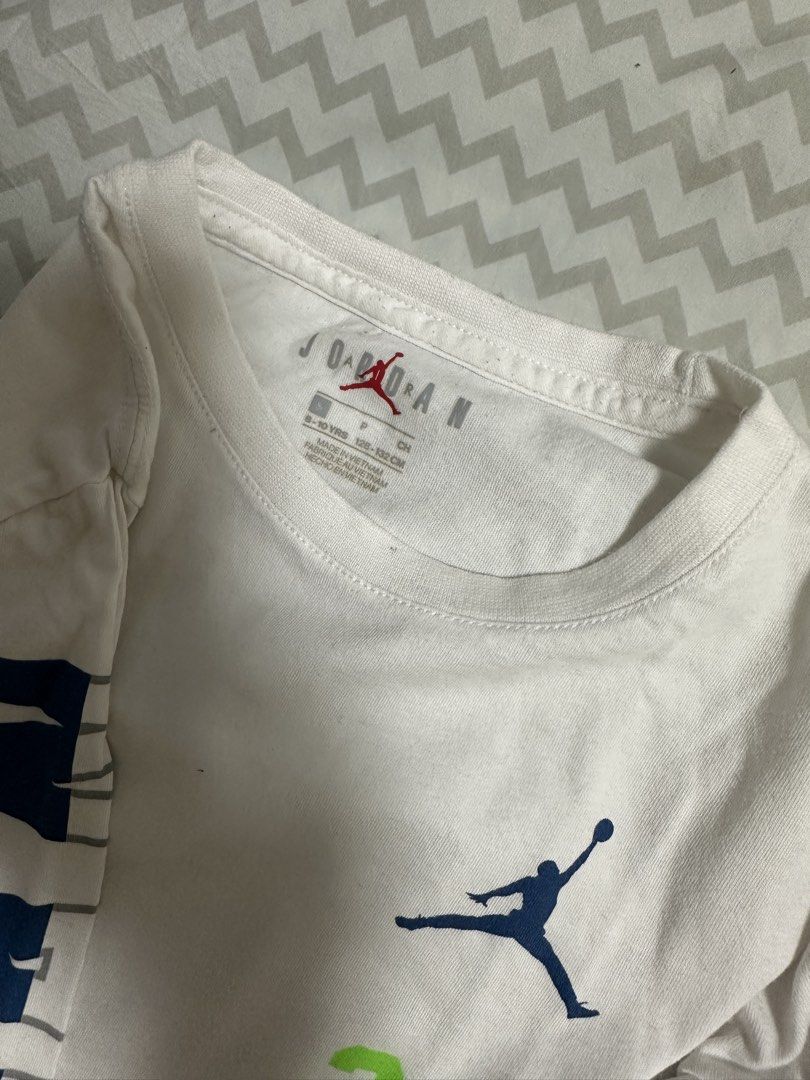 Jordan Long Sleeve Shirt (Category: Babies & Kids Fashion) located in Manila. Submitted by classywardrobemanila (Listing ID 1435828017, Image 3). Description: - White long sleeve shirt - Jordan logo and '23' on front - 'JORDAN' print on sleeves - Crew neck - Size: 8-10 years old - Minor stains present.