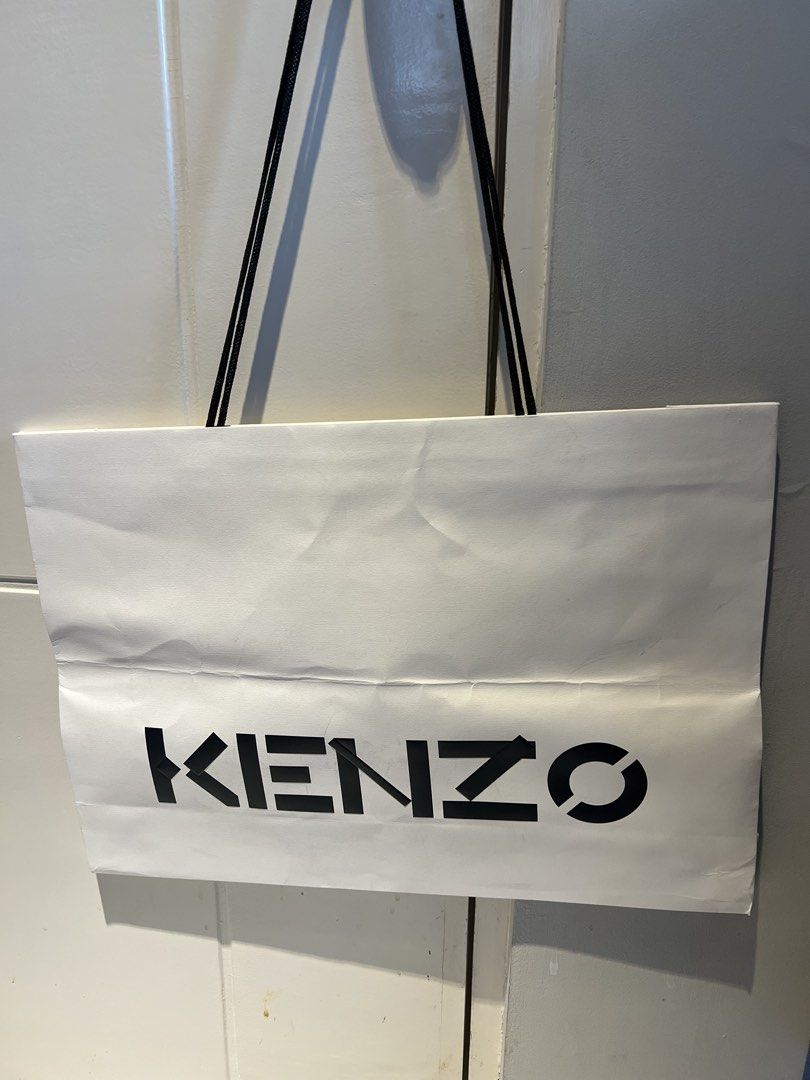 Kenzo Shopping Bag large (Category: Luxury Bags & Wallets) located in Makati City. Submitted by marckyboy (Listing ID 1435811315, Image 1). Description: - Authentic Kenzo shopping bag - White paper exterior - Black Kenzo logo - Black rope handles - Perfect for shopping or as a stylish accessory.