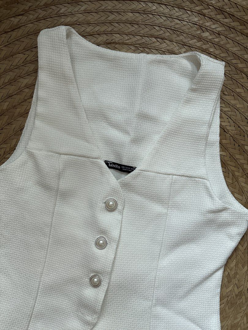 Lovito White Vest with Pearl Buttons (Category: Sleeveless) located in Manila. Submitted by _foryou (Listing ID 1435779625, Image 2). Description: - Lovito white vest - Textured fabric - V-neck design - Features three pearl-like buttons - Tailored fit - Slightly flared bottom - Sleeveless top.