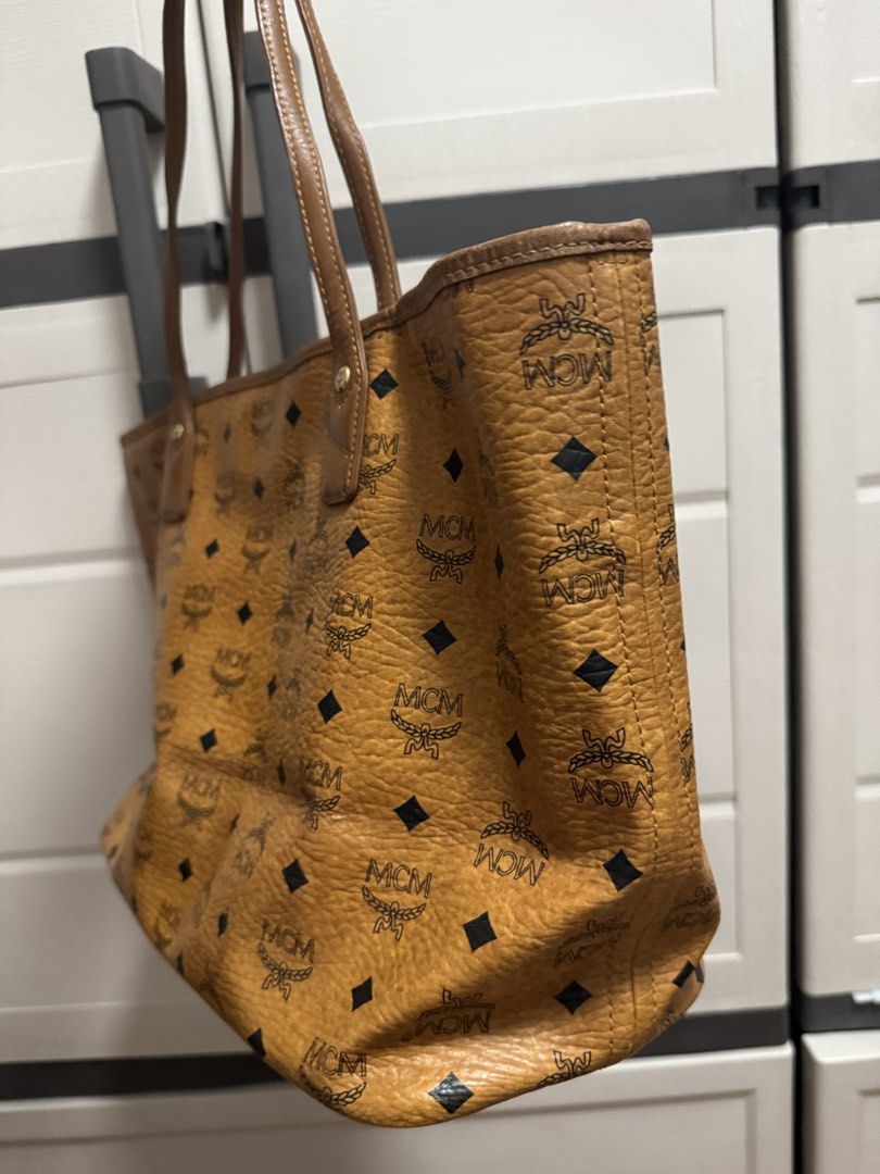 MCM Visetos Coated Canvas Tote Bag (Category: Luxury Bags & Wallets) located in Caloocan City. Submitted by r_h_e_a10 (Listing ID 1435864390, Image 2). Description: - Authentic MCM tote bag - Iconic Visetos coated canvas with center stripe - Brown leather handles and trim - Gold-tone metal logo plate - Interior pocket - Includes certificate of authenticity - Light-colored interior lining.