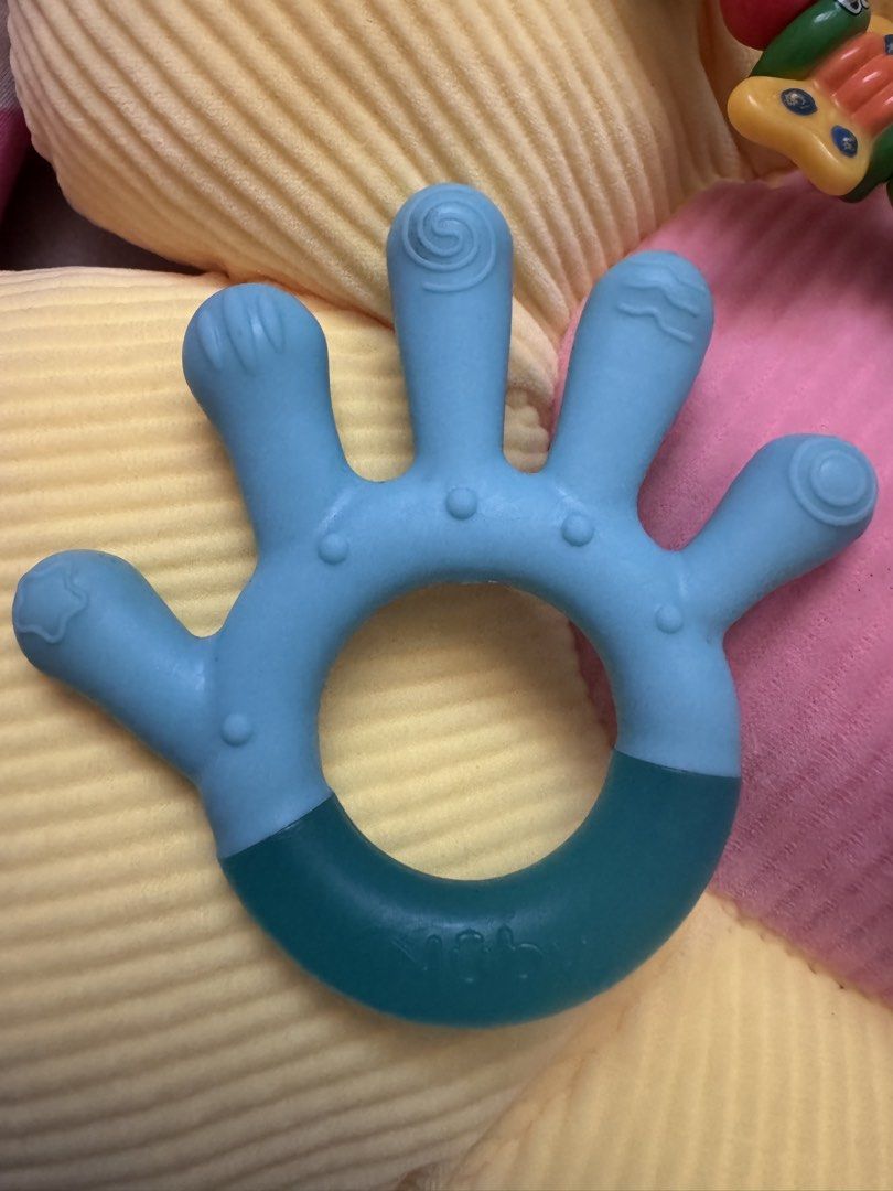 Nuby Teething Set (Category: Soothers & Pacifiers) located in Manila. Submitted by sufelme_online_shop (Listing ID 1435782634, Image 3). Description: - Nuby Teething Set: - Includes a bracelet, hand-shaped teether, and pacifier-shaped teether. - Bracelet features colorful beads with bee, ladybug, and butterfly. - Hand-shaped teether is blue with a darker blue grip. - Pacifier-shaped teether is purple. - Designed to soothe and comfort babies durin