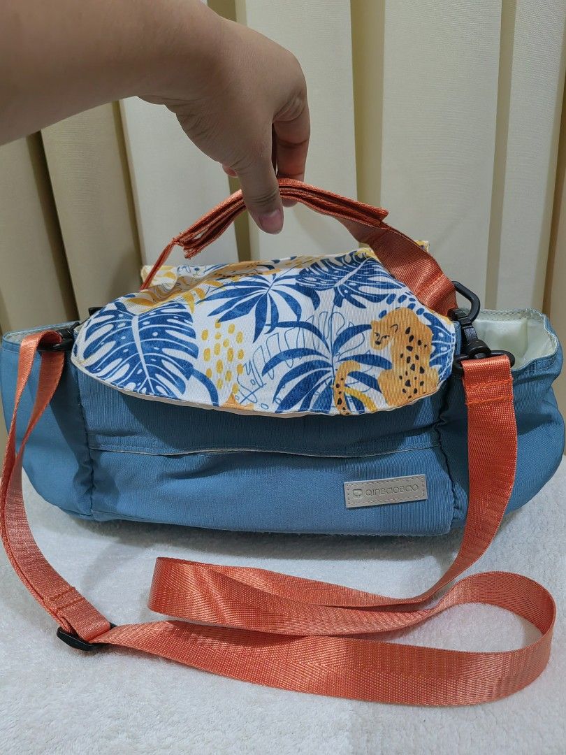 stroller bag organizet with sling (Category: Strollers) located in Makati City. Submitted by prelovedtreatedwithlove (Listing ID 1435832416, Image 2). Description: - Vibrant blue organizer bag - Features a patterned flap - Comes with an orange shoulder strap and handle - Spacious, light-colored interior - Includes tissue holder - Perfect for gateway with kiddo - Normal sign of use need wash A-102.