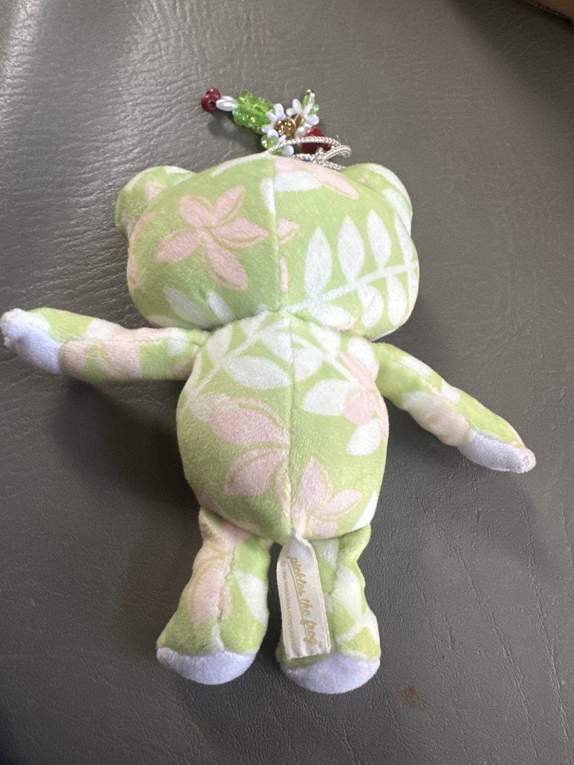Pickles the Frog charms (Category: Plushies & Soft Toys) located in Cainta. Submitted by shopbyyna (Listing ID 1435783519, Image 2). Description: - Pickles the Frog plush toy - Green and pink floral pattern - Includes a beaded charm - Tag reads "Pickles the Frog" and "1984 Nakajima Corporation" - Smiling face and outstretched arms - Collectible item.