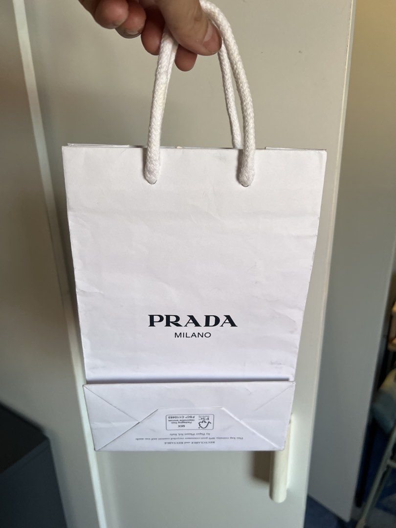 Prada Milano Paper Bag (Category: Luxury Bags & Wallets) located in Makati City. Submitted by marckyboy (Listing ID 1435814041, Image 2). Description: - Authentic Prada Milano paper bag - White exterior with black Prada Milano logo - Features white rope handles - Perfect for small items or display.