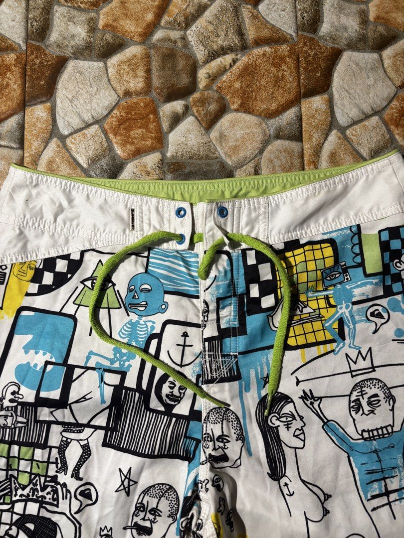 Quiksilver Board Shorts with Graphic Print (Category: Swim Trunks & Board Shorts) located in Paranaque City. Submitted by coveredtags (Listing ID 1435715955, Image 2). Description: - Quiksilver board shorts - Unique colorful graphic print - White base with various figures and patterns - Drawstring closure - White waistband with green accents - Lightweight material - Ideal for water activities.