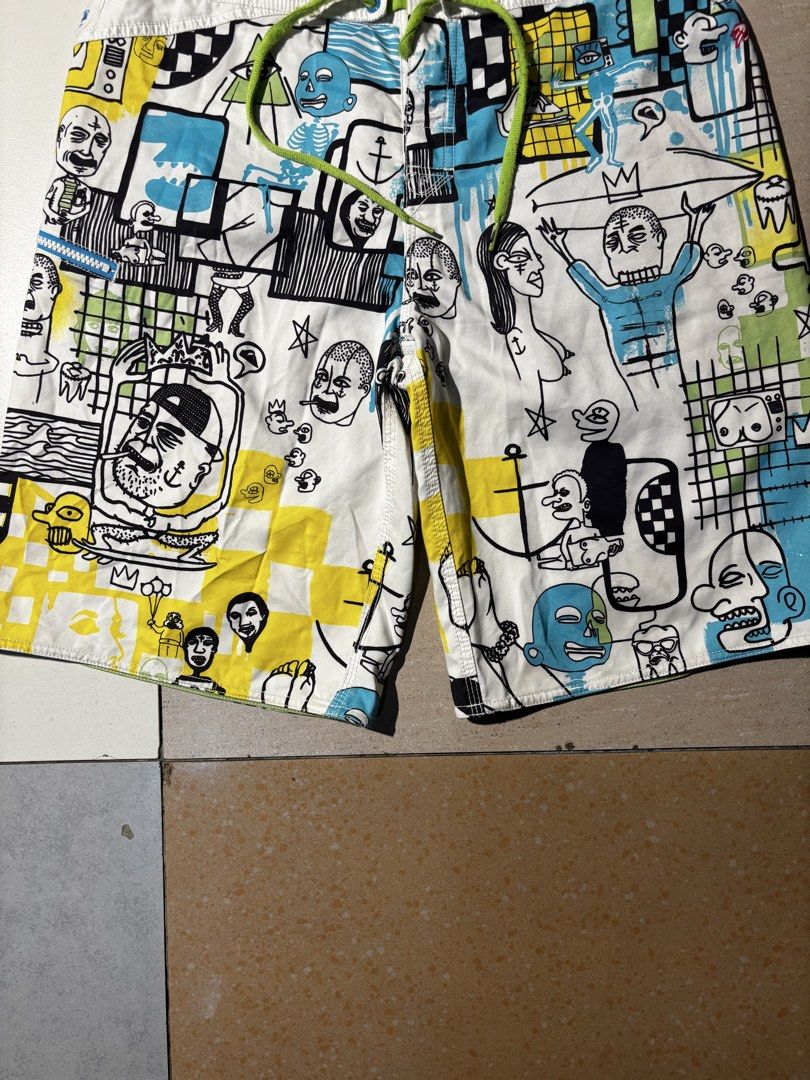 Quiksilver Board Shorts with Graphic Print (Category: Swim Trunks & Board Shorts) located in Paranaque City. Submitted by coveredtags (Listing ID 1435715955, Image 3). Description: - Quiksilver board shorts - Unique colorful graphic print - White base with various figures and patterns - Drawstring closure - White waistband with green accents - Lightweight material - Ideal for water activities.
