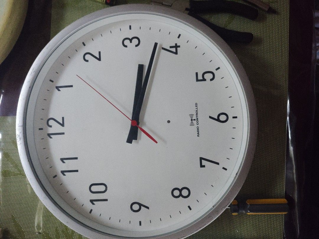 Radio Controlled Wall Clock (Category: Clocks) located in Manila. Submitted by fdrakearon89191 (Listing ID 1435883034, Image 1). Description: - Radio-controlled wall clock - Simple white face with black numerals and hands - Silver-colored frame - Japanese model Y823-0 - Weighs 1.5kg.