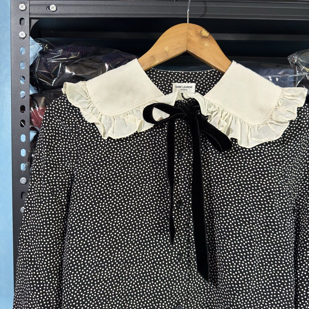 SAINT LAURENT - Peter Pan Collar Polka Blouse (Category: Blouses) located in Cavite. Submitted by gooditems.cavite (Listing ID 1435906001, Image 3). Description: - Saint Laurent blouse - Black and white polka dot pattern - White ruffle collar - Black velvet tie - Ruffled cuffs - Made in Italy - Size: F34, 155/80Y 18.5 width 24 length 14 shoulder 22 sleeves.