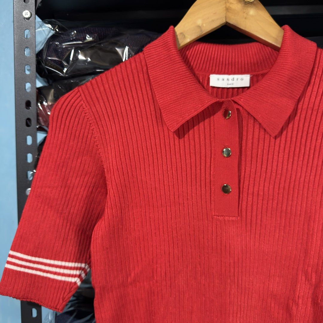 SANDRO PARIS - Red Ribbed Polo Shirt (Category: Shirts) located in Cavite. Submitted by gooditems.cavite (Listing ID 1435905641, Image 3). Description: Fits small to large womens Stretchable fabric 15x22 dimensions - Sandro red polo shirt - Ribbed texture - Classic polo collar - Short sleeves with white stripes - Three-button placket - White stripes on bottom hem - Sandro brand label visible - Made in Hong Kong.