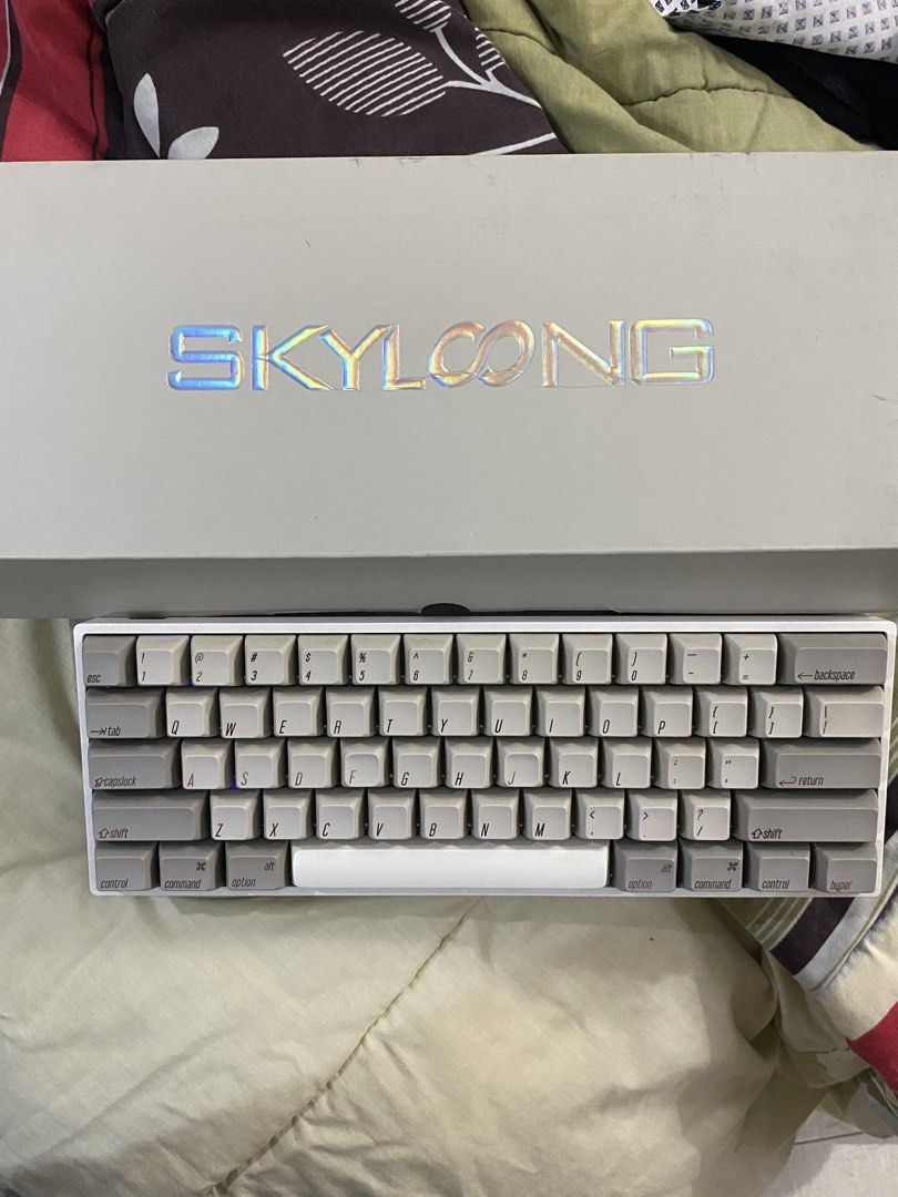 Skyloong GK61S (CUSTOM) mechanical keyboard (Category: Computer Keyboard) located in Manila. Submitted by jii_sels (Listing ID 1435829279, Image 1). Description: Details: -Bought the kit in 2022 from Skyloong official store 🍊app - Gateron Milky Yellow, lubed - Stabs are tuned as well - Generic chinese PBT SA profile keycaps (wasd a bit faded) - Original aluminum plate, foam modded - Supports bluetooth -Issue: missing rubber feet from front side 