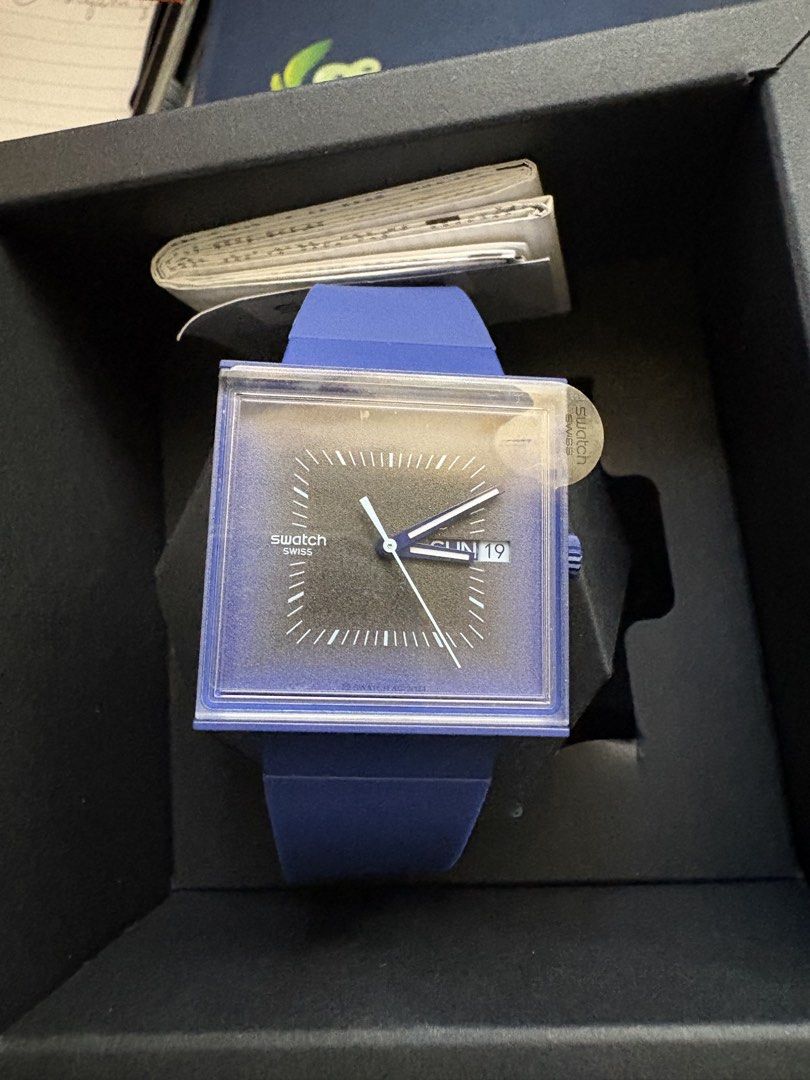 Swatch Squarely Blacklight (Category: Women's Watches) located in Manila. Submitted by maximmus8 (Listing ID 1435868622, Image 2). Description: Stylish Swatch watch with a unique square face. Features a black dial with white hands and markers. The watch has a blue strap and a matching blue square frame. Comes with its original box and documentation. A perfect accessory for any occasion..