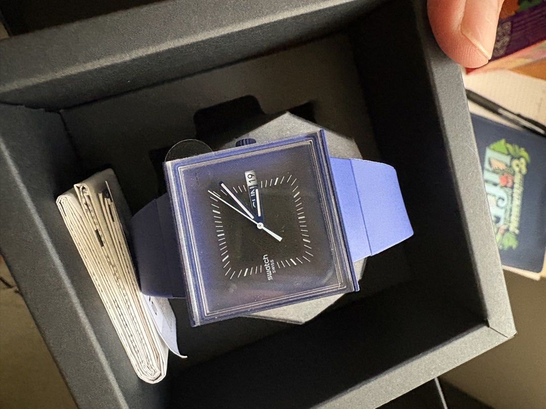Swatch Squarely Blacklight (Category: Women's Watches) located in Manila. Submitted by maximmus8 (Listing ID 1435868622, Image 1). Description: Stylish Swatch watch with a unique square face. Features a black dial with white hands and markers. The watch has a blue strap and a matching blue square frame. Comes with its original box and documentation. A perfect accessory for any occasion..