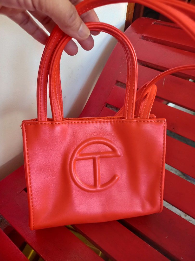 Telfar Shopping Bag Small Red orange (Category: Luxury Bags & Wallets) located in Tuguegarao City. Submitted by zenphoenix-7ad615 (Listing ID 1435791765, Image 1). Description: - Telfar Shopping Bag in Red orange - Structured design - Features a top handle and shoulder strap - Telfar logo embossed on the front - Interior lined with orange fabric - Snap closure.
