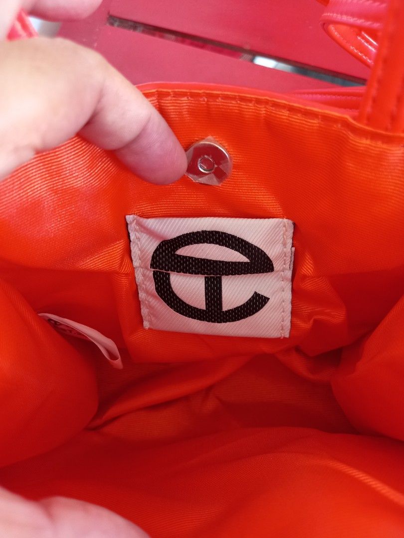 Telfar Shopping Bag Small Red orange (Category: Luxury Bags & Wallets) located in Tuguegarao City. Submitted by zenphoenix-7ad615 (Listing ID 1435791765, Image 2). Description: - Telfar Shopping Bag in Red orange - Structured design - Features a top handle and shoulder strap - Telfar logo embossed on the front - Interior lined with orange fabric - Snap closure.