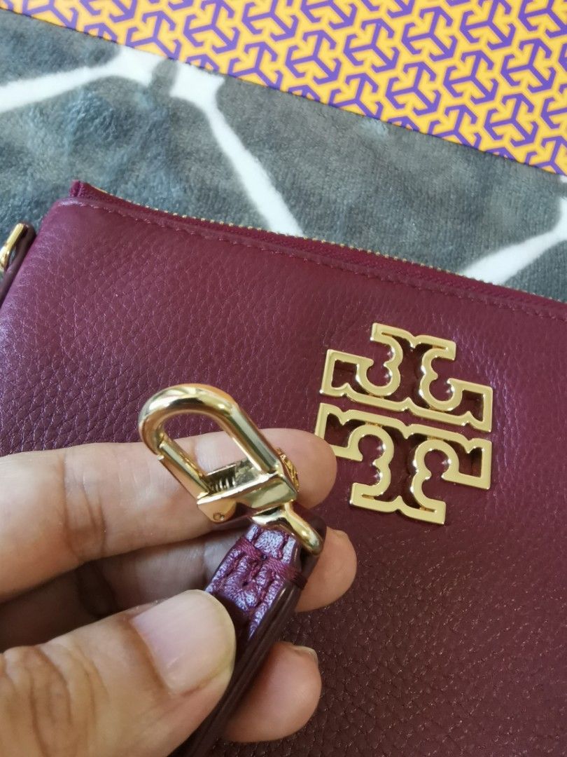 Tory Burch Wristlet (Category: Luxury Bags & Wallets) located in Makati City. Submitted by denvergirl1119 (Listing ID 1435746261, Image 3). Description: - Tory Burch wristlet in burgundy - Gold-tone hardware - Wrist strap included - Zip-around closure - Interior with card slots - Tory Burch logo on front - Comes with matching box.