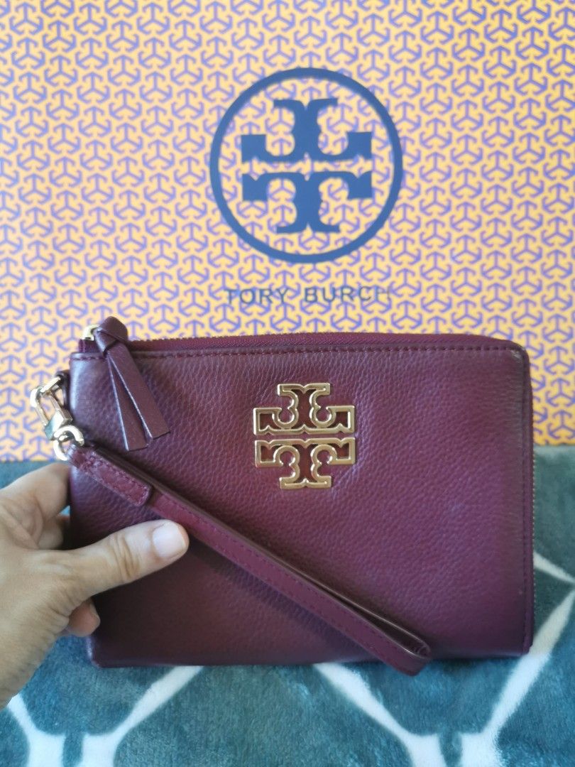 Tory Burch Wristlet (Category: Luxury Bags & Wallets) located in Makati City. Submitted by denvergirl1119 (Listing ID 1435746261, Image 2). Description: - Tory Burch wristlet in burgundy - Gold-tone hardware - Wrist strap included - Zip-around closure - Interior with card slots - Tory Burch logo on front - Comes with matching box.
