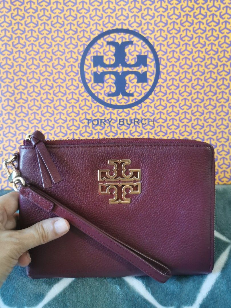 Tory Burch Wristlet (Category: Luxury Bags & Wallets) located in Makati City. Submitted by denvergirl1119 (Listing ID 1435746261, Image 1). Description: - Tory Burch wristlet in burgundy - Gold-tone hardware - Wrist strap included - Zip-around closure - Interior with card slots - Tory Burch logo on front - Comes with matching box.