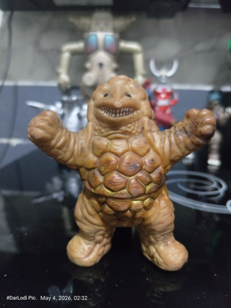 Ultraman Kaiju Monster Figure unmarked. (Category: Figurines & Statues) located in Pasay City. Submitted by mancave07 (Listing ID 1435901057, Image 1). Description: - Vintage Ultraman monster figure - Features a brown, textured body - Detailed face and raised arms - Unique segmented body and tail design - Perfect for Ultraman fans and collectors.