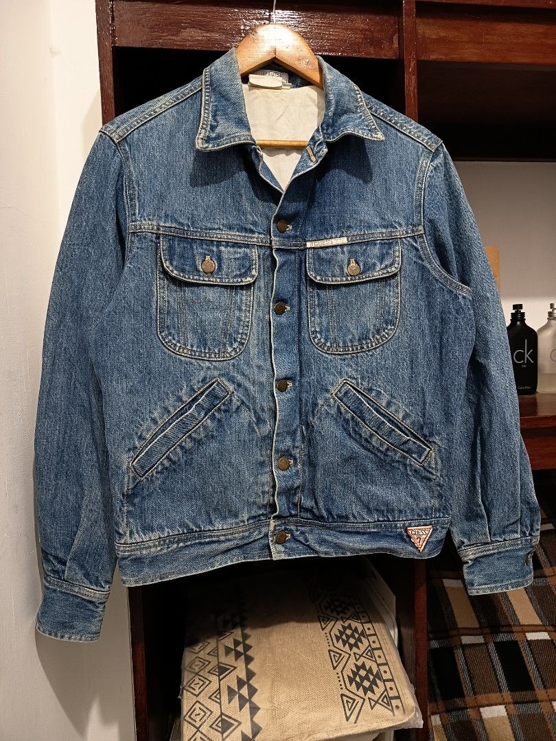 Vintage Guess Denim Trucker Logo Jacket (Category: Coats, Jackets and Outerwear) located in Dagupan City. Submitted by plugofallthreads (Listing ID 1435901714, Image 1). Description: Vintage Guess Denim Trucker Logo Jacket Made in USA Size: Men's Small Length: 25 inches Width: 22 inches Sleeve Length: 29 inches Price: Php 1,500 plus sf DM TO PURCHASE.