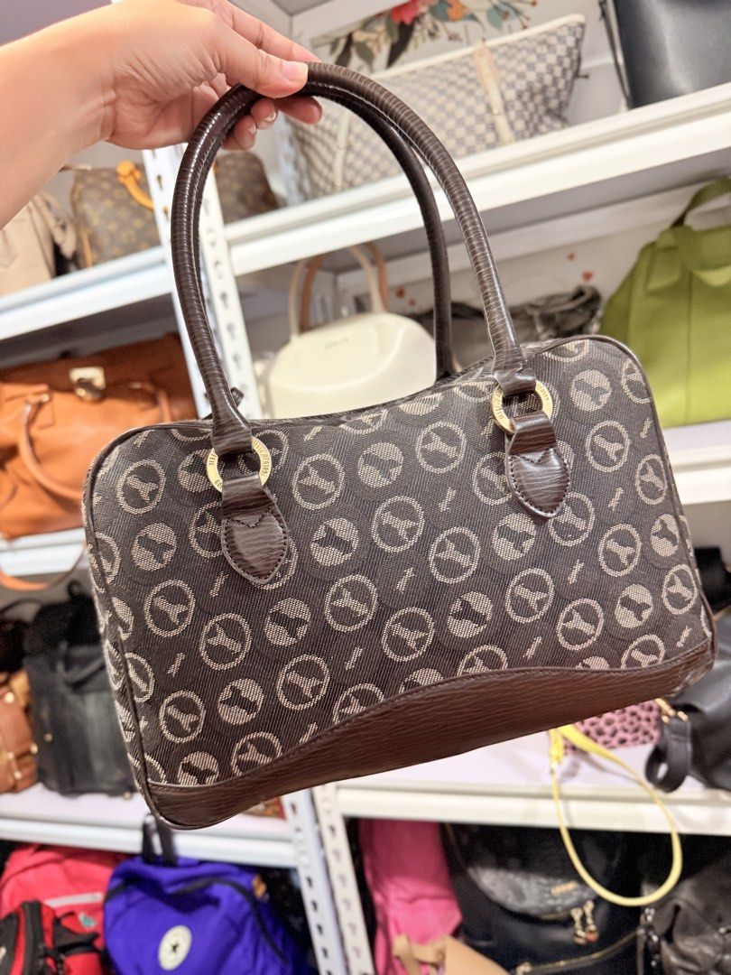 Vintage Handbag with Logo (Category: Luxury Bags & Wallets) located in Cainta. Submitted by peppychute (Listing ID 1435908247, Image 3). Description: - Vintage handbag - Unique logo pattern - Brown base and handles - Gold-colored hardware - Zipper closure - Includes a small charm - Brand name visible - Classic and elegant design.