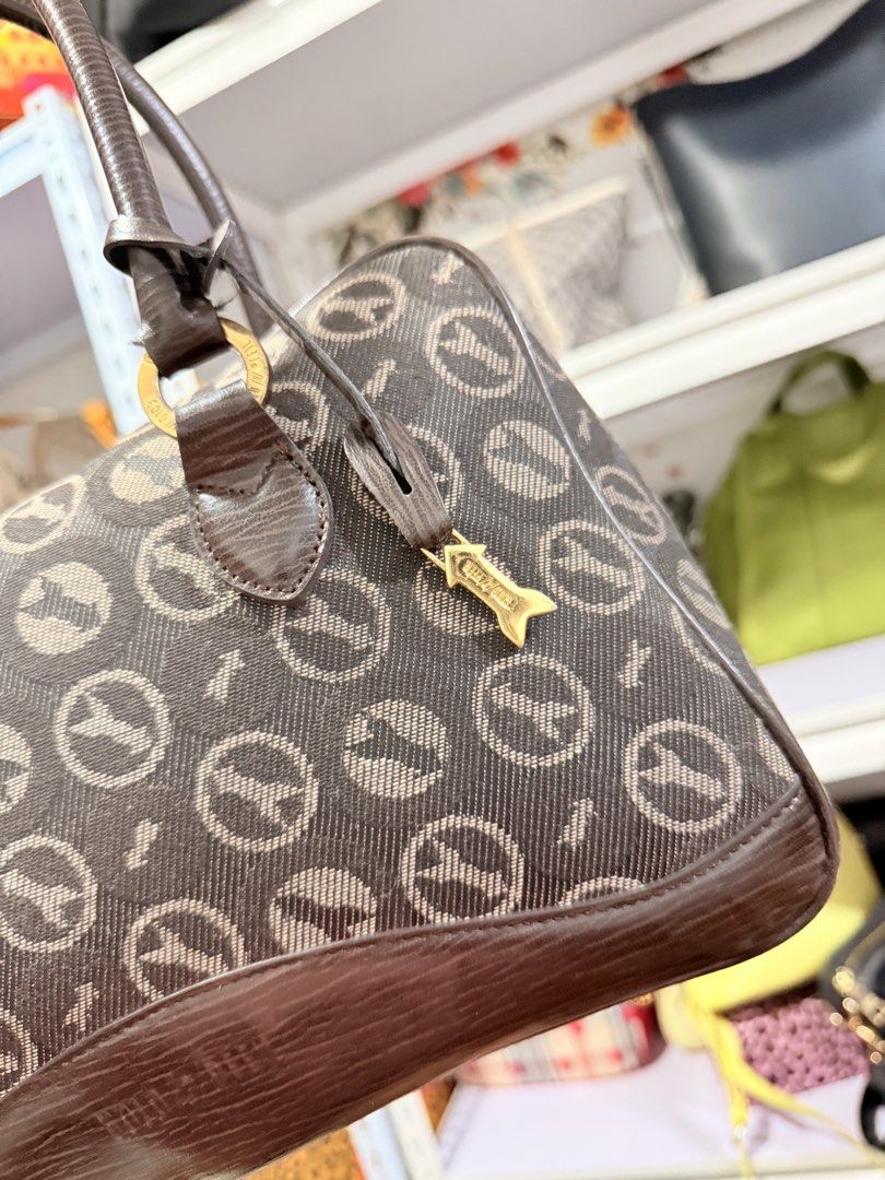 Vintage Handbag with Logo (Category: Luxury Bags & Wallets) located in Cainta. Submitted by peppychute (Listing ID 1435908247, Image 2). Description: - Vintage handbag - Unique logo pattern - Brown base and handles - Gold-colored hardware - Zipper closure - Includes a small charm - Brand name visible - Classic and elegant design.