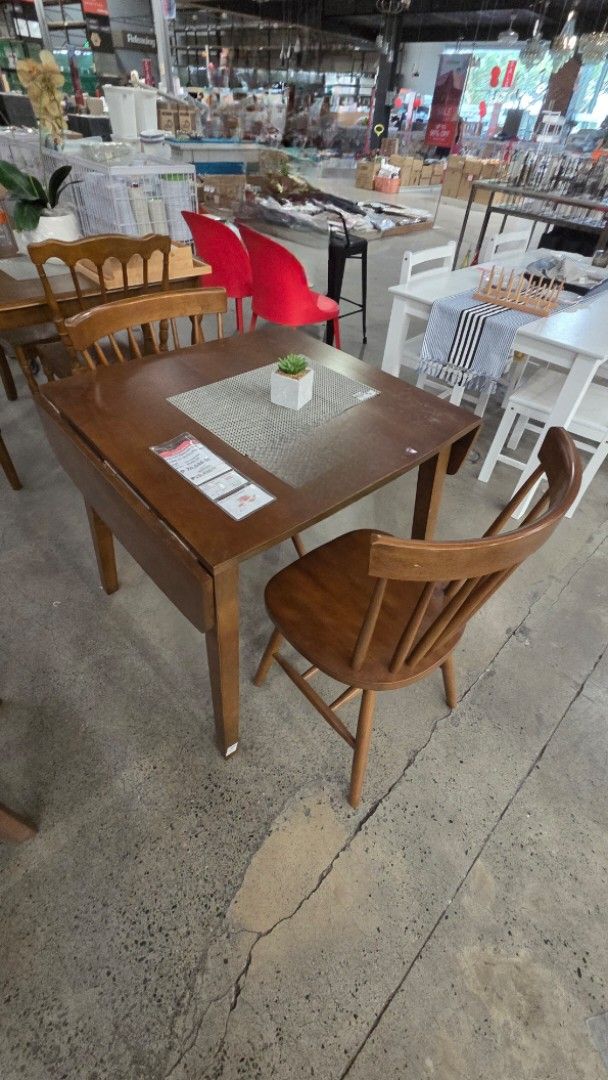 Wooden Dining Table with 2 Chairs (Category: Tables & Sets) located in Makati City. Submitted by realsnapshoppe (Listing ID 1435733299, Image 2). Description: - Space-saving dining set ideal for apartments. - Includes a drop-leaf wooden table. - Features two matching spindle-back chairs. - Table has a square shape. - Crafted from wood with a warm, natural finish..