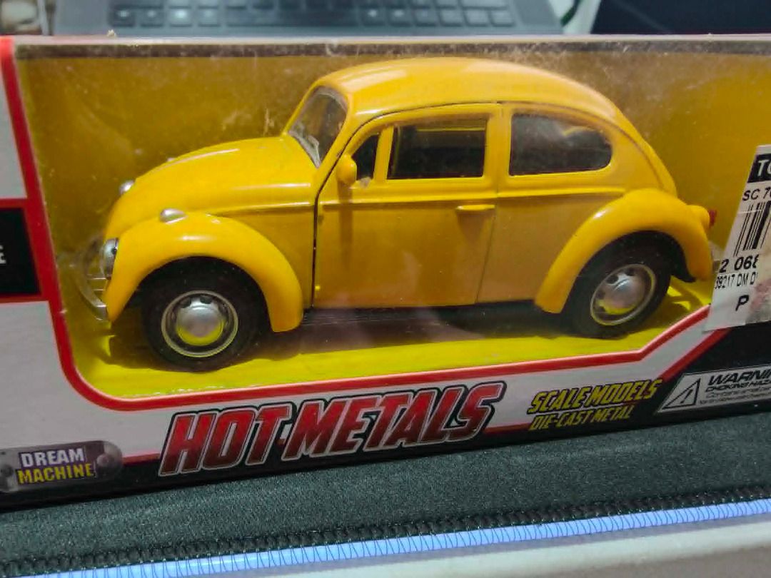 Yellow Volkswagen Beetle Toy Car (Category: Vehicle & Diecast Models) located in Manila. Submitted by cooldude0613 (Listing ID 1435714792, Image 1). Description: - Yellow Volkswagen Beetle toy car - Brand new, in original packaging - Features detailed wheels and windows - Miniature replica of the classic Beetle design - Displayed on a yellow base.