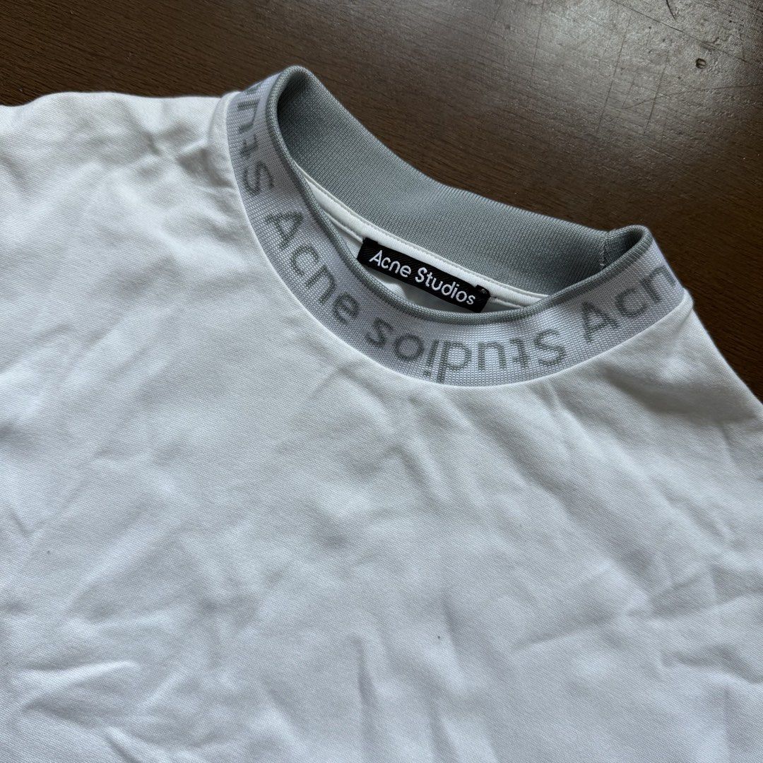 Acne Studios White T-shirt with Logo Neckline (Category: Tshirts & Polo Shirts ) located in Manila. Submitted by myclosetstylist (Listing ID 1440776819, Image 3). Description: - Features iconic Acne Studios logo printed around the neckline - Classic fit with short sleeves - Made in Portugal - Perfect staple piece, easy to dress up or down.
