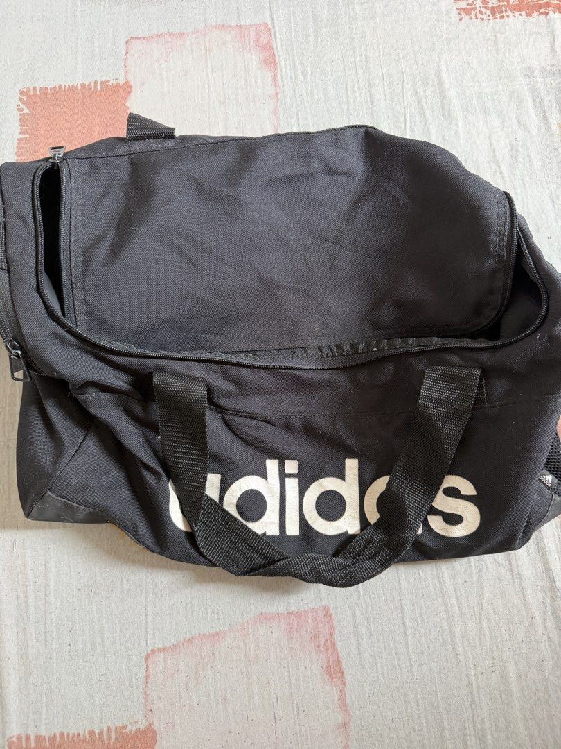 Adidas Black Duffel Bag (Category: Backpacks) located in Manila. Submitted by chiechums (Listing ID 1440795200, Image 1). Description: - Black Adidas duffel bag - Perfect for gym sessions or short getaways - Spacious main compartment with an internal pocket - Convenient front zip pocket for essentials - Two sturdy carry handles for easy transport.