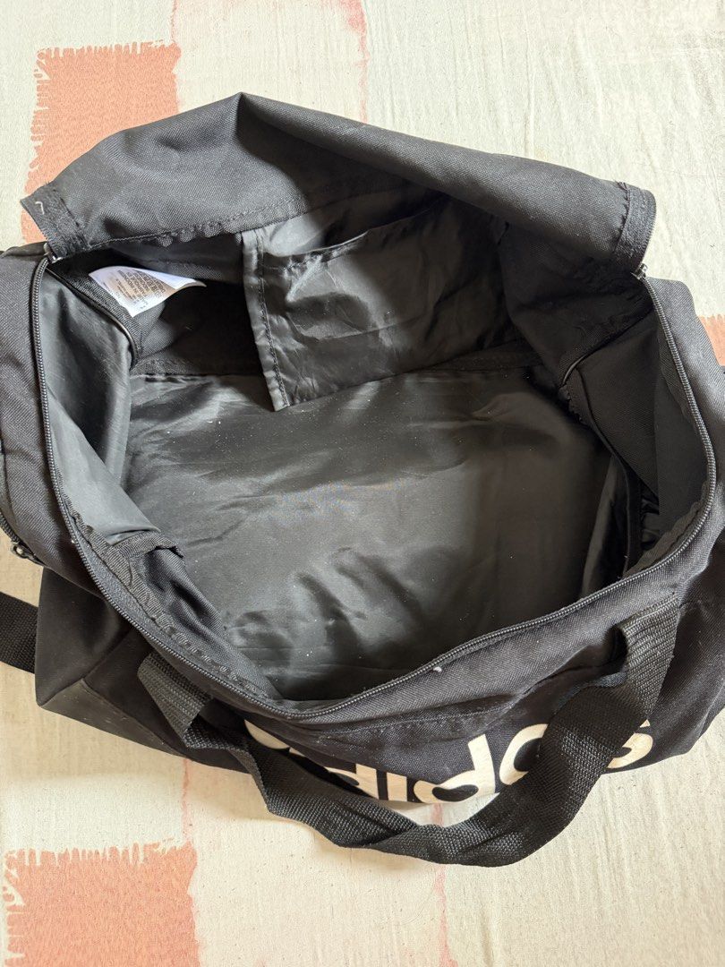 Adidas Black Duffel Bag (Category: Backpacks) located in Manila. Submitted by chiechums (Listing ID 1440795200, Image 2). Description: - Black Adidas duffel bag - Perfect for gym sessions or short getaways - Spacious main compartment with an internal pocket - Convenient front zip pocket for essentials - Two sturdy carry handles for easy transport.