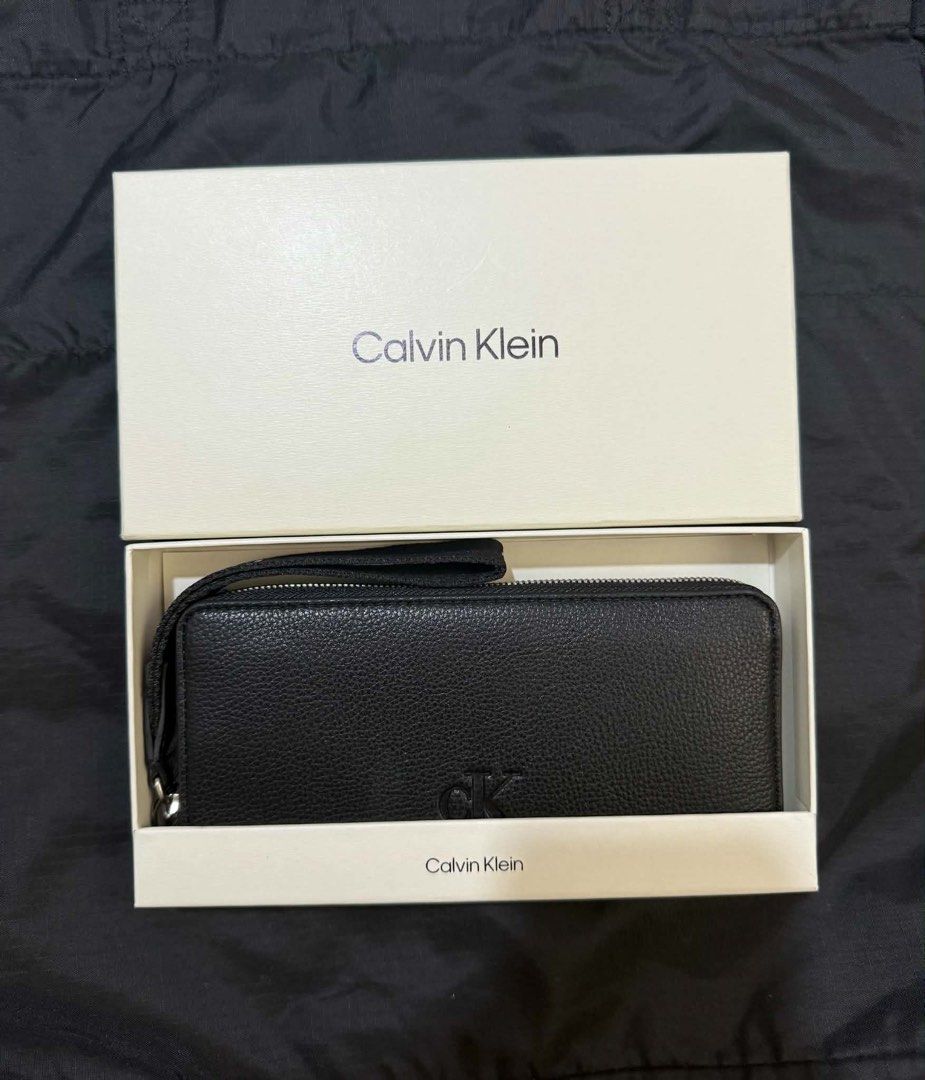 Authentic Calvin Klein Black Leather Zip Around Wristlet Wallet (Category: Wallets & Card holders) located in Manila. Submitted by deoksun (Listing ID 1440816542, Image 1). Description: - Authentic Black Calvin Klein wallet - Detachable wrist strap - Multiple card slots and compartments - Built-in RFID blocking card - Comes in original box - Perfect for organizing your essentials NEGOTIABLE .